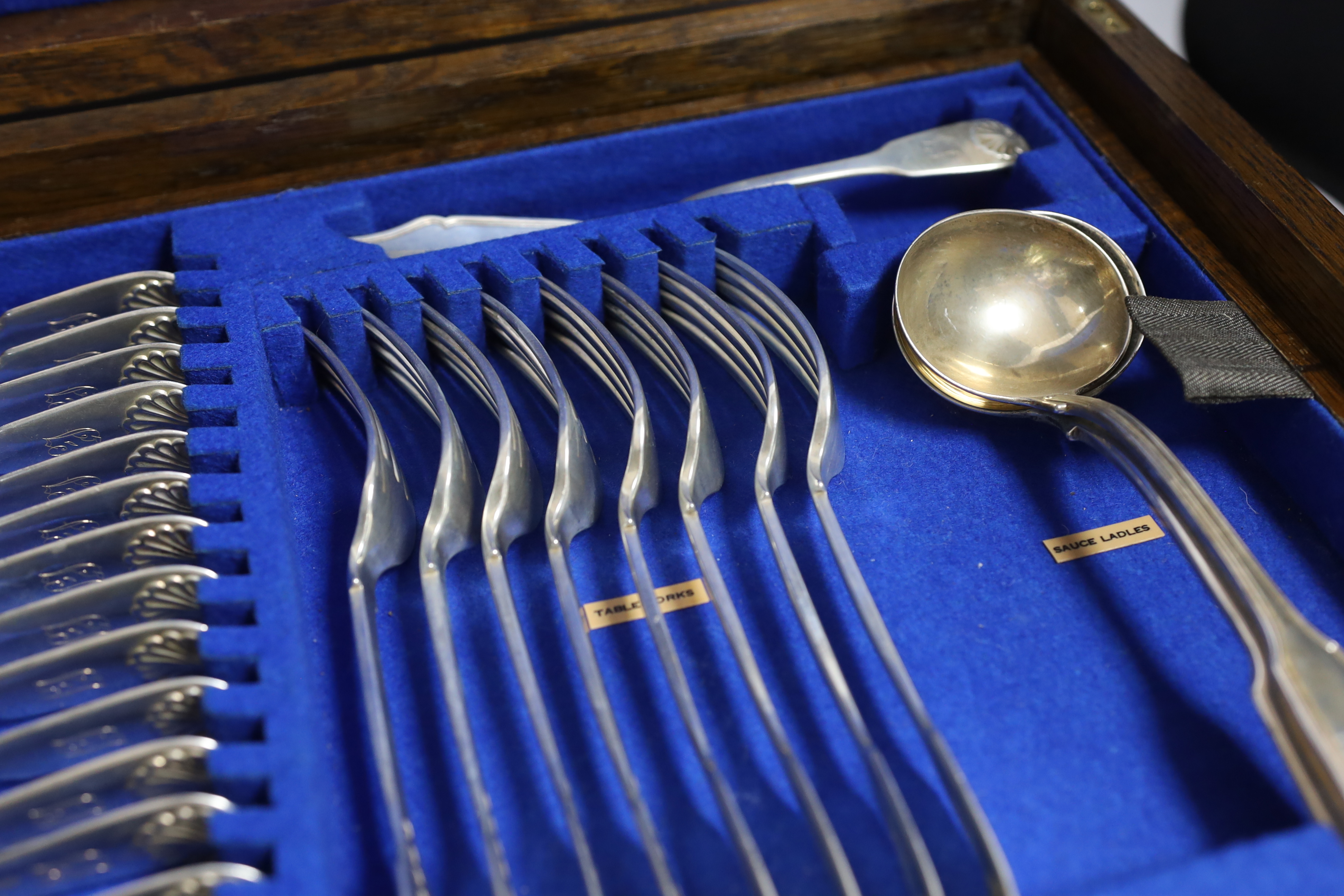 A Victorian oak cased matched canteen of silver fiddle and shell pattern flatware, by John & Henry Lias & H.J. Lias & Son